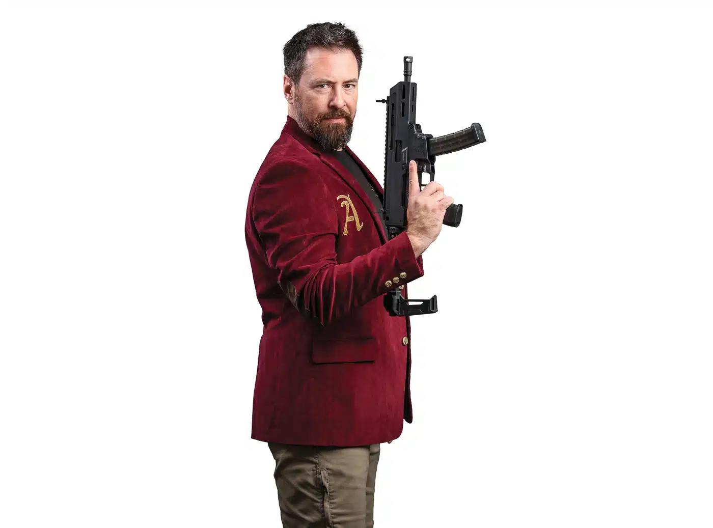Scott Conditt in the crimson Cantius Award jacket with its gold embroidered A, holding a Springfield Armory Kuna 9mm pistol.